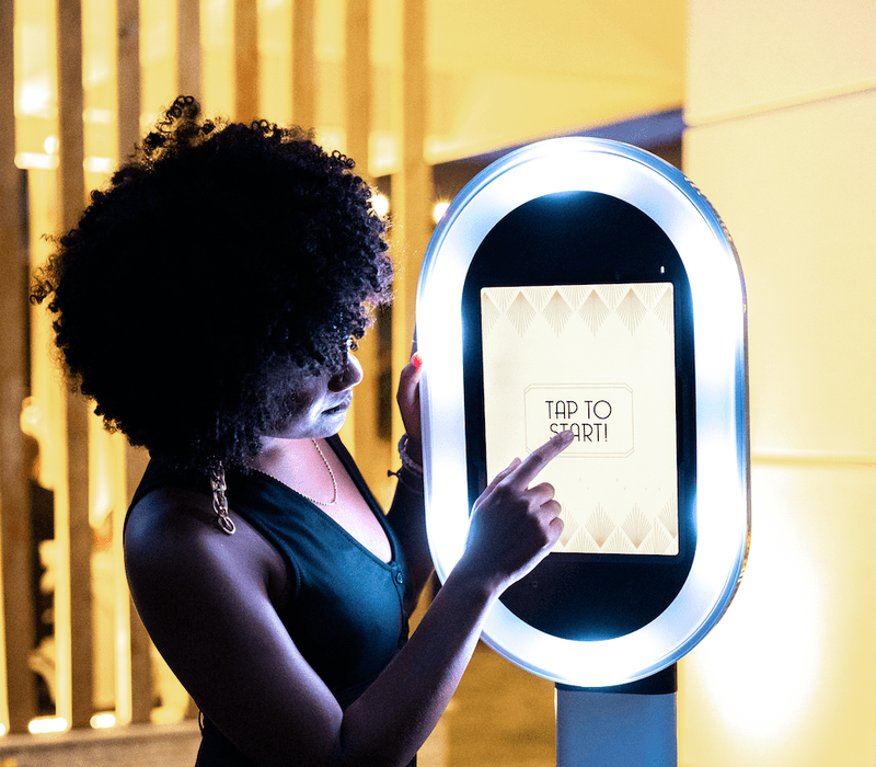 Guest tapping the touchscreen on an open-air photo booth